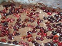 Press halved and stoned sour cherries into the...