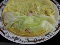 Put the omelette on a tortilla. Garnish half of...