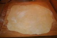 Use a rolling pin to spread the dough on floured...