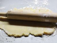 Use a rolling pin to spread the dough on a floured...