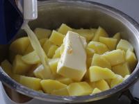 Strain the cooked potatoes, add butter and milk. ...