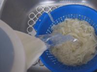 Drain the cooked noodles in a strainer and pour...