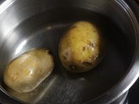 Wash the potatoes and cook them in their skins....