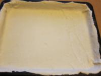 Use a rolling pin to spread the puff pastry in the...