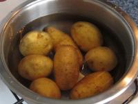 Boil the potatoes in water until they are almost...